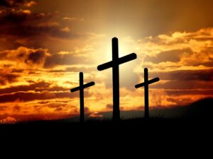 Cruzes em silhueta ao pôr do sol, símbolo do amor de Deus