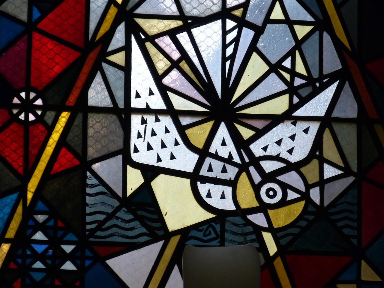Vitral de igreja com pomba, representando Pentecostes e a descida do Espírito Santo