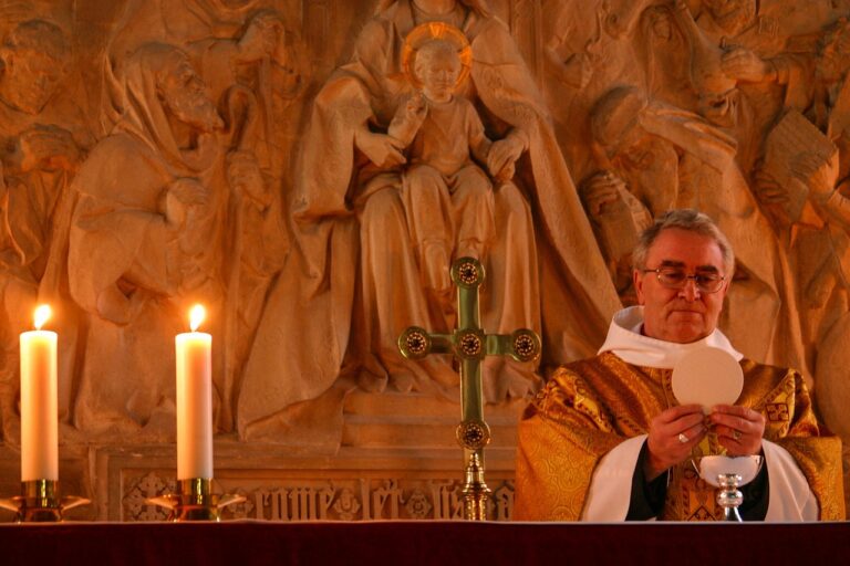 Sacerdote celebrando a Missa com cálice no altar, momento da oração eucarística