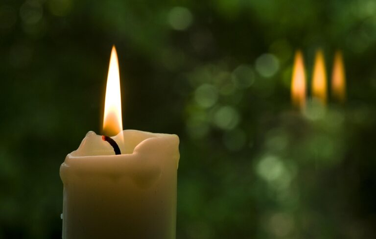 Vela acesa em ambiente de meditação, símbolo de louvor à Santíssima Trindade