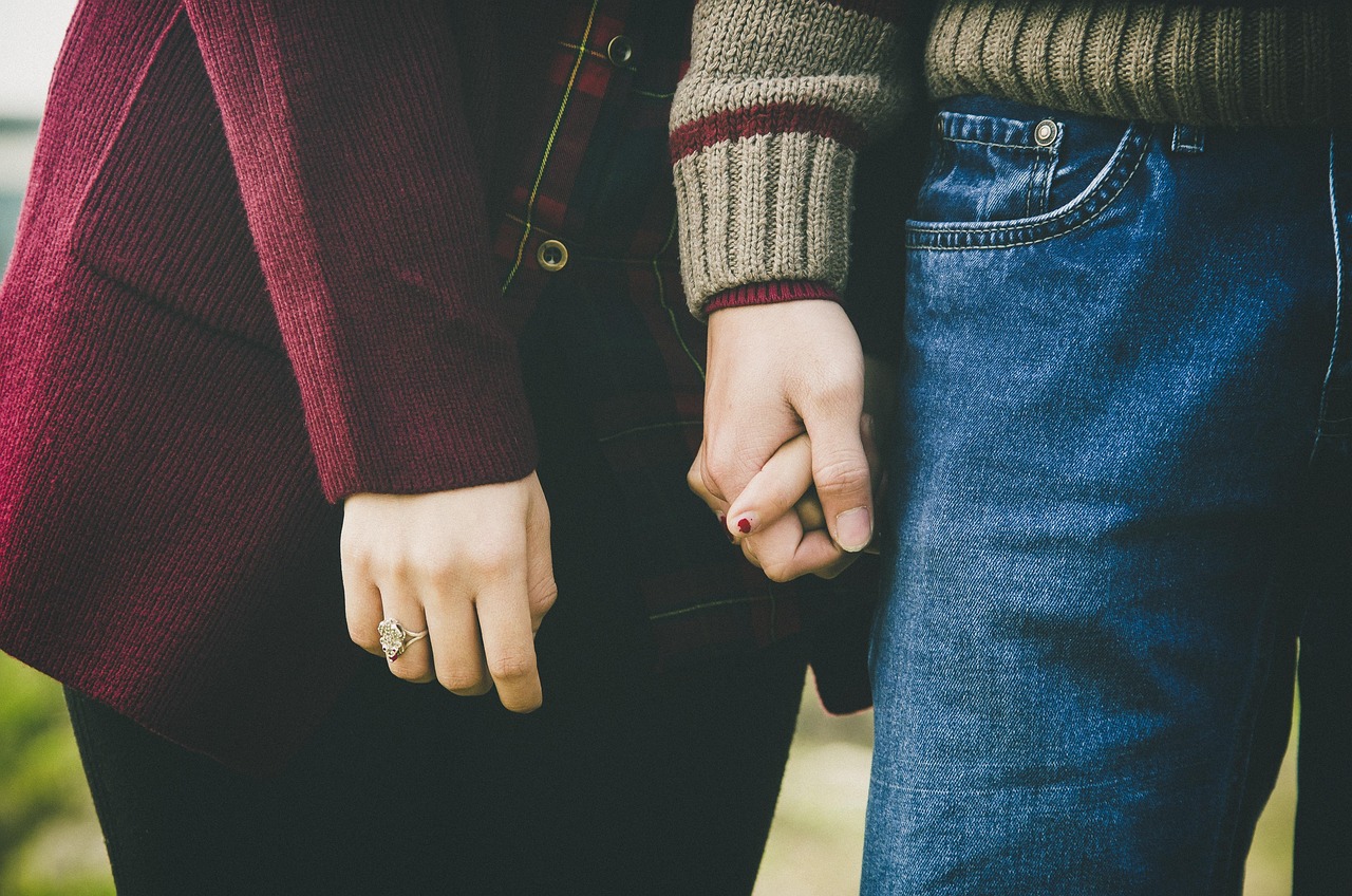 Casal de mãos dadas caminhando juntos, símbolo de companheirismo
