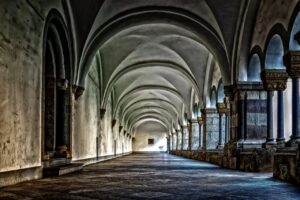 Claustro de mosteiro, corredor com arcos, símbolo da vida consagrada