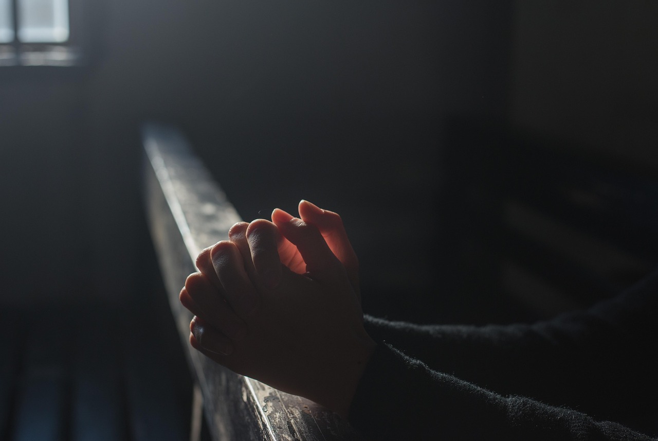 Mãos em oração com luz, símbolo de devoção e súplica a São José