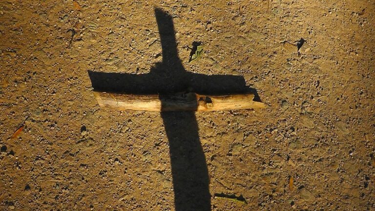 Cruz de madeira com sombra, símbolo da Paixão de Cristo e da Sagrada Face