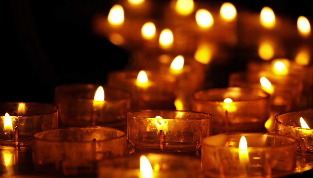 Velas acesas em contemplação, símbolo da meditação sobre a Sagrada Face de Jesus