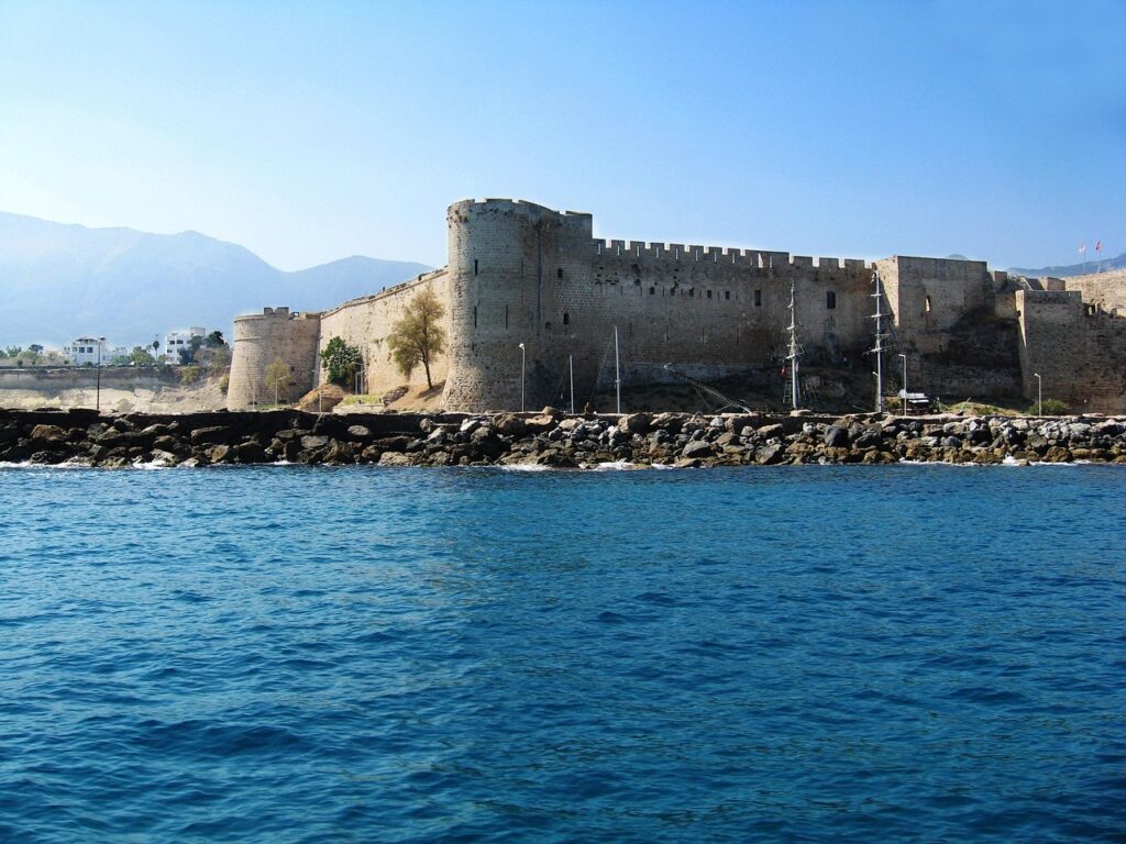 Castelo litorâneo no Mediterrâneo, referência ao porto de Óstia onde Santa Mônica morreu