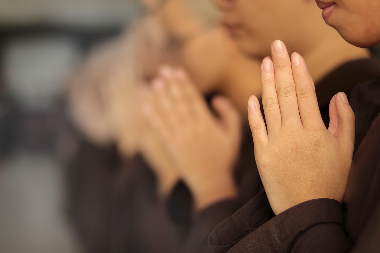 Mãos em oração, símbolo de fé contemplativa e devoção a Santa Teresa d'Ávila